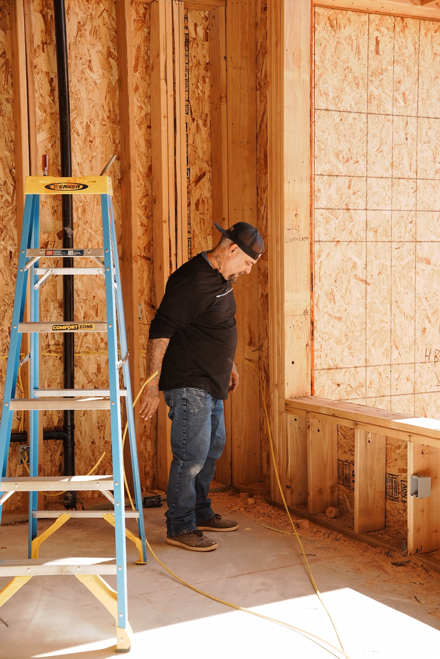 Wider view of a Blackstone Electrical crew running wire in a framed home